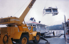 The upper level of the boat has been cut apart from the lower and a crane is assisting with the transfer of the top to a waiting trailer. This section was hauled, as a separate load, a week after the boat arrived in Manitoba.